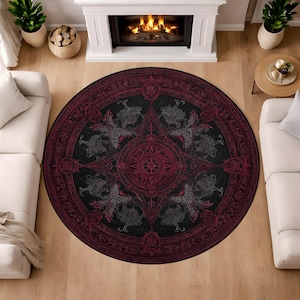May include: A round area rug with a detailed, gothic-inspired design. The rug features a black background with a central starburst pattern and ornate red and gray accents. The design includes stylized figures and geometric shapes, creating a striking visual effect.