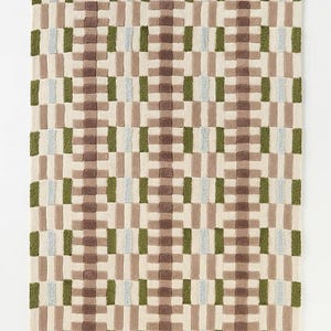 Peut inclure: Un tapis rectangulaire avec une bordure ondul&eacute;e et un motif g&eacute;om&eacute;trique. Le tapis pr&eacute;sente un motif r&eacute;p&eacute;titif de rectangles marron, verts et bleu clair sur un fond cr&egrave;me. Les dimensions du tapis ne sont pas visibles.