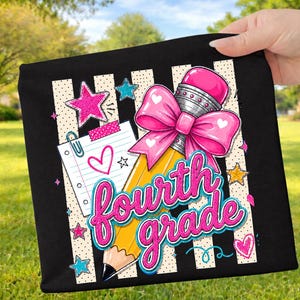 May include: A black fabric item featuring a graphic design of a yellow pencil with a large pink bow, a piece of lined notebook paper with a pink heart, and the text "fourth grade" in pink glittery script, surrounded by pink, blue, and yellow stars.