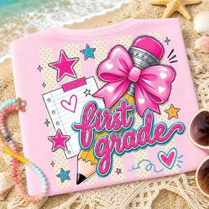 May include: A light pink t-shirt featuring a graphic print of a yellow pencil with a large pink bow, a piece of lined notebook paper with a heart, and the text "first grade" in bright pink glittery script, surrounded by small stars and hearts.