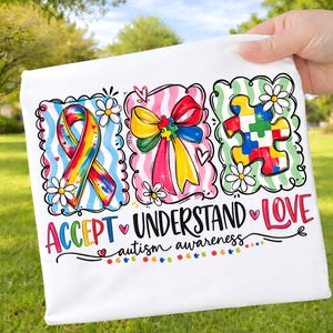 May include: White fabric with colorful illustrations and text promoting autism awareness. The design includes a rainbow ribbon, a bow, and a puzzle piece, with the words "ACCEPT, UNDERSTAND, LOVE" and "autism awareness."