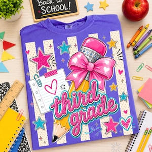 May include: A purple t-shirt featuring a graphic of a yellow pencil with a large pink bow, a lined notepad with a heart, and the text third grade in pink script. The design includes various colourful stars and dots on a striped background.