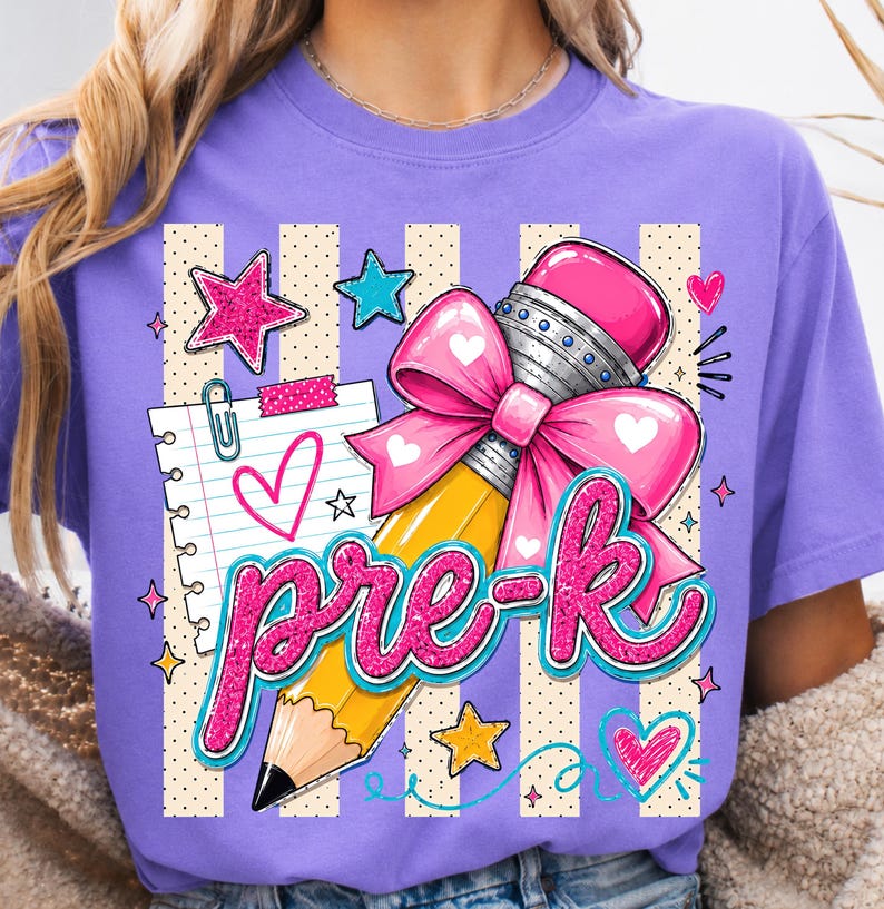 May include: A purple t-shirt featuring a graphic design of a yellow pencil with a pink bow, a sheet of lined paper, and the text "pre-k" in glittery pink letters. The background includes beige vertical stripes with dots and various star and heart shapes.