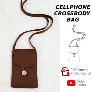 Könnte beinhalten: Eine braune Umhängetasche für Mobiltelefone mit langem Riemen und Holzknopfverschluss. Die Tasche hat einen Klappenverschluss und ein schlichtes Design. Der Text auf dem Bild lautet "CELLPHONE CROSSBODY BAG".