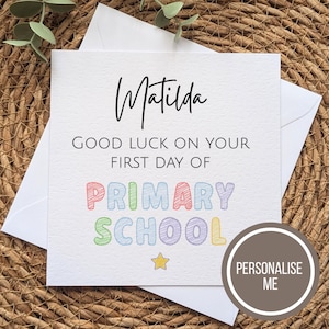 May include: A square white greeting card with a black script name Matilda at the top. Below, the text reads GOOD LUCK ON YOUR FIRST DAY OF PRIMARY SCHOOL in black, with the words PRIMARY SCHOOL in colorful, scribbled-style block letters.