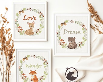 May include: Three framed art prints with woodland animal illustrations. Each print features a different animal: a deer, a bear, and a fox, surrounded by a wreath of leaves, berries, and acorns. The prints have the words "Love", "Dream", and "Wonder".