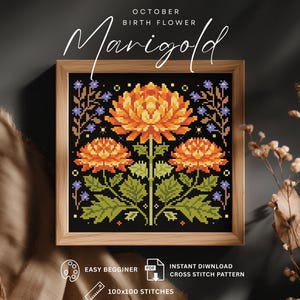 May include: A framed cross-stitch pattern featuring three orange marigold flowers with green leaves against a black background. The text "October Birth Flower Marigold" is above the flowers. The frame is made of light brown wood. The pattern is 100x100 stitches.