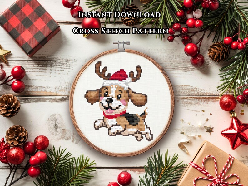 May include: A cross stitch pattern in a wooden embroidery hoop featuring a cartoon beagle dog wearing a red and white Santa hat with reindeer antlers. The text INSTANT DOWNLOAD CROSS STITCH PATTERN is printed above the hoop on a white surface.