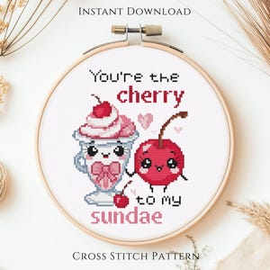 May include: A cross-stitch pattern in a wooden hoop features a cute sundae and cherry design with the text "You're the cherry to my sundae." The design includes pink and red colors, perfect for a Valentine's Day gift.