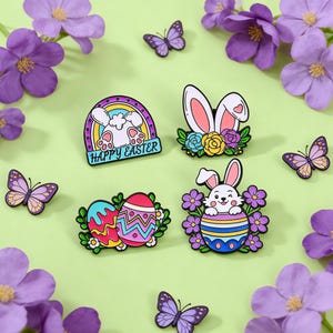 May include: Easter-themed enamel pins featuring bunnies, decorated eggs, and butterflies. The pins are in various shapes and colors, including a rainbow, floral accents, and the text "Happy Easter". The background is a light green color with purple flowers.