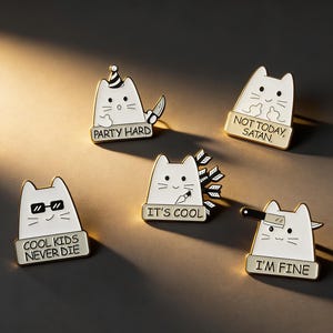 Puede incluir: Conjunto de cinco pines de esmalte de gato blanco con detalles negros y bordes dorados. Cada pin presenta una frase diferente: "PARTY HARD", "NOT TODAY, SATAN", "COOL KIDS NEVER DIE", "IT'S COOL" e "I'M FINE". Los gatos tienen varios accesorios.