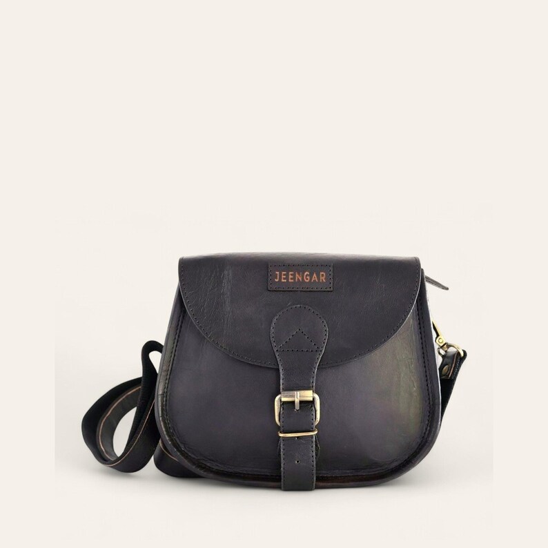 The Marwari Sling in Black, saddle-flap full-grain leather sling with stitched Jeengar label and strap, front view