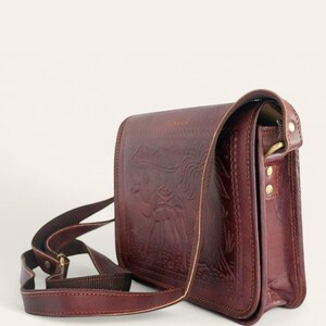 The Jaisalmer Sling in Cherry, side three-quarter view showing the gusset and the adjustable leather strap