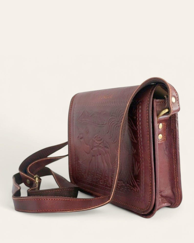 The Jaisalmer Sling in Cherry, side three-quarter view showing the gusset and the adjustable leather strap