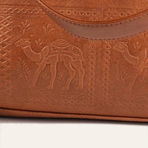 Close view of the hand-tooled camel caravan imprint on the lower front of The Abhaneri Tote