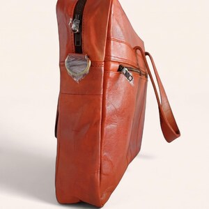 The Mehrangarh Briefcase standing upright, showing its slim depth and top zip