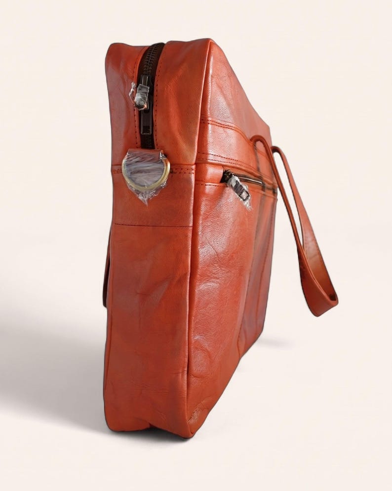 The Mehrangarh Briefcase standing upright, showing its slim depth and top zip