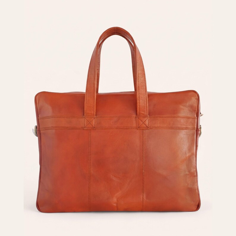 The Mehrangarh Briefcase in tan leather, front view, handles raised