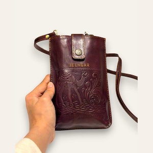 The Osian Mobile Sling in Cherry, hand-embossed camel motif on real leather, front view