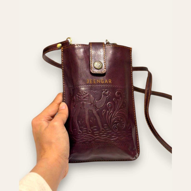 The Osian Mobile Sling in Cherry, hand-embossed camel motif on real leather, front view