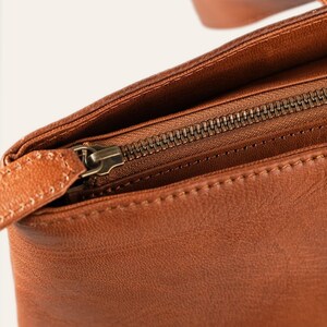 The full-width antique-finish metal top zip and leather pull of The Abhaneri Tote