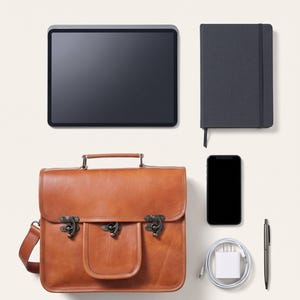 The Malani Messenger shown with an 11-inch tablet, A5 journal, phone, charger and pen to show what it holds (AI-generated)