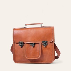 The Malani Messenger in natural-brown full-grain leather, front view with twist-lock pocket and top handle