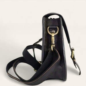 The Marwari Sling in Black, side profile showing the slim 6 cm depth and brass clip