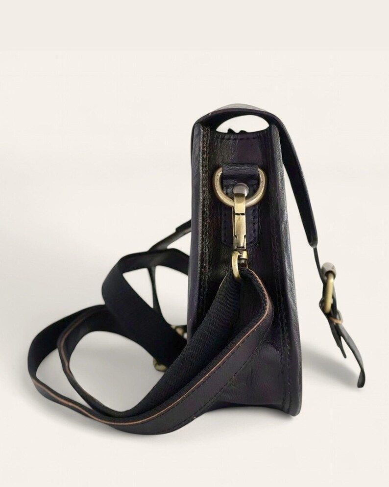 The Marwari Sling in Black, side profile showing the slim 6 cm depth and brass clip
