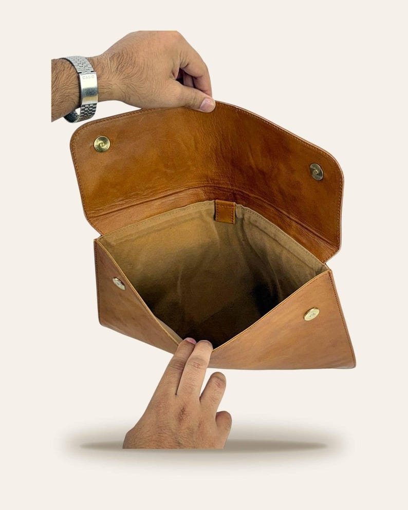 The Barmer Tech Sleeve held open to show the soft suede-lined interior and brass magnetic snaps