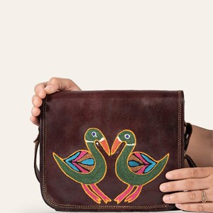 The Moruda Sling held in one hand, showing its compact everyday scale