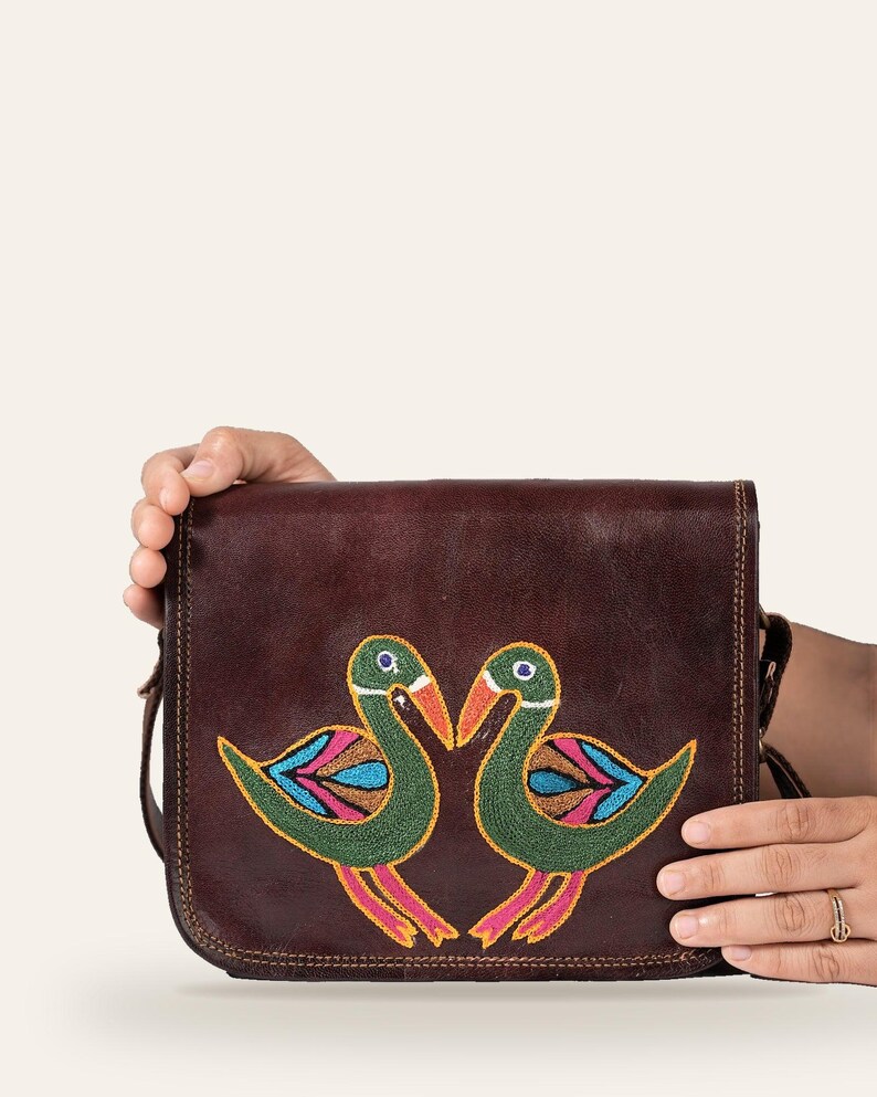 The Moruda Sling held in one hand, showing its compact everyday scale