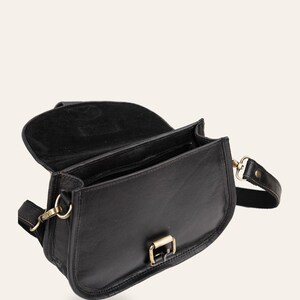 The Marwari Sling in Black with the flap open, showing the lined interior