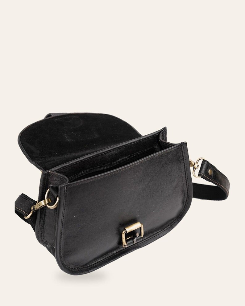 The Marwari Sling in Black with the flap open, showing the lined interior