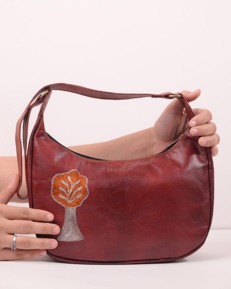 The Kashida Shoulder Bag Padmini in Cherry held in hand