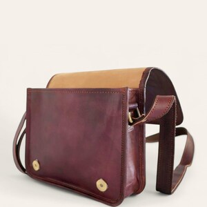 The Jaisalmer Sling in Cherry with the flap open, showing the lined interior