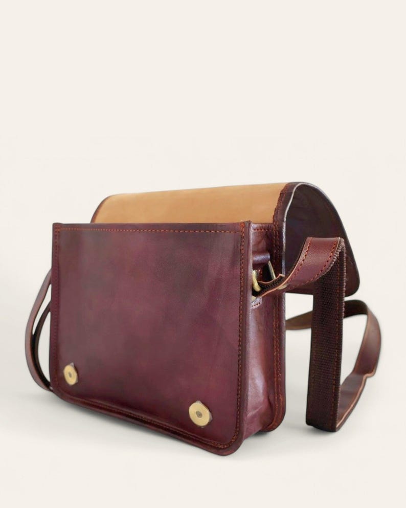 The Jaisalmer Sling in Cherry with the flap open, showing the lined interior