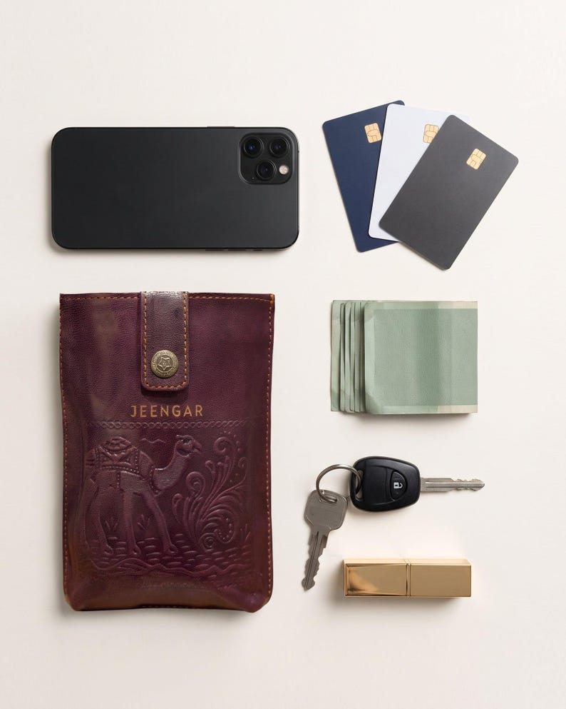 The Osian Mobile Sling shown with a phone, three cards, folded notes, keys and a lipstick to show what it holds (AI-generated)