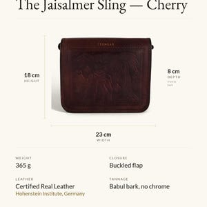 Specification card for The Jaisalmer Sling in Cherry: 23 cm wide, 18 cm high, 8 cm deep, 365 g, buckled flap, full-grain leather, babul bark tannage. Made by Mohan.