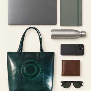 The Rambagh Tote shown with a 13-inch laptop, a notebook, a water bottle, a phone, a wallet and sunglasses to show what it holds (AI-generated)