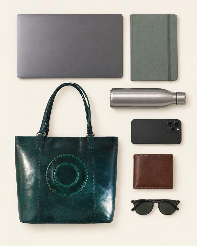 The Rambagh Tote shown with a 13-inch laptop, a notebook, a water bottle, a phone, a wallet and sunglasses to show what it holds (AI-generated)