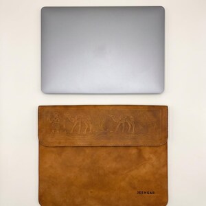 The Barmer Tech Sleeve, 13-inch edition, shown beside the laptop it is cut for (AI-generated)
