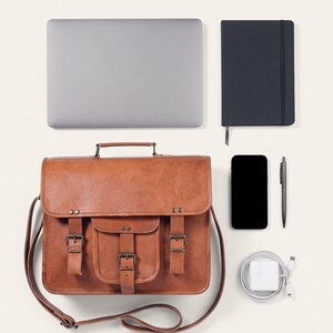 The Mewad Messenger, 13-inch size, shown with a 13-inch laptop, A5 notebook, phone, charger and pen to show what it holds (AI-generated)