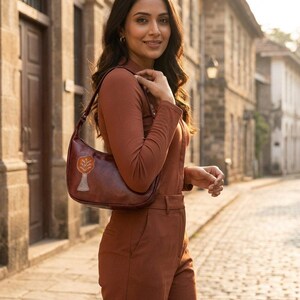 The Kashida Shoulder Bag Padmini in Cherry worn on the shoulder (AI-generated)