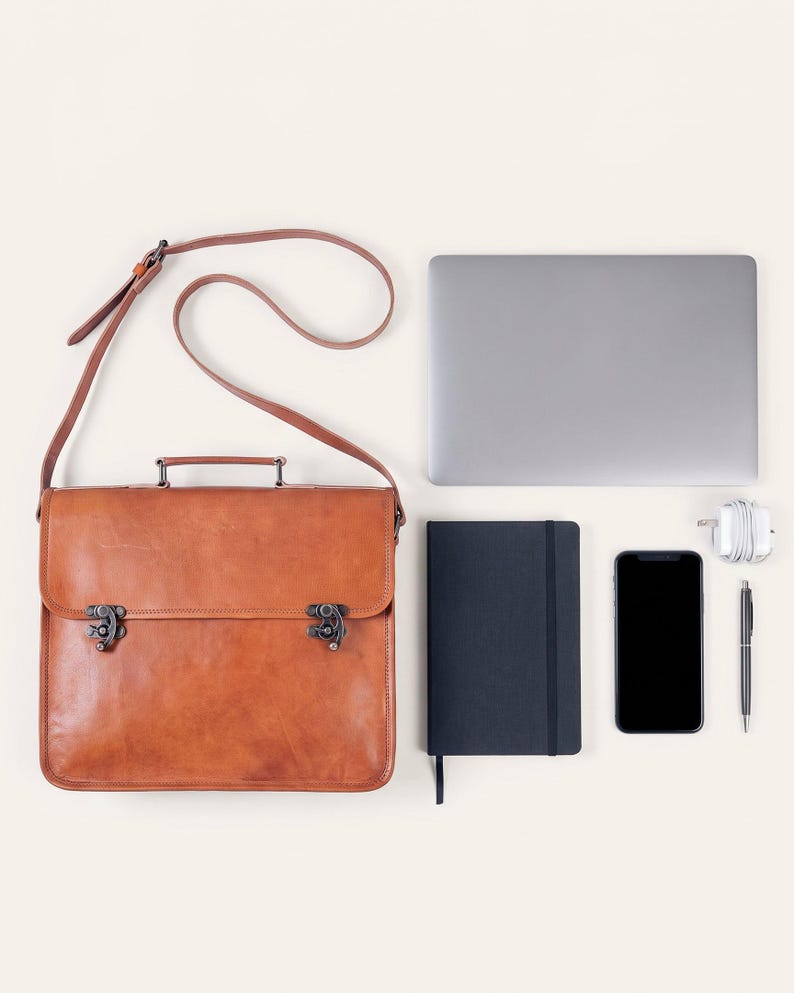 The Jodhpur Messenger, 13-inch size, shown with a 13-inch laptop, A5 notebook, phone, charger and pen to show what it holds (AI-generated)