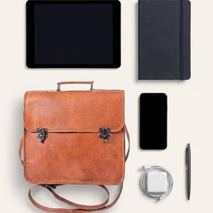 The Jodhpur Messenger, 11-inch size, shown with an 11-inch tablet, A5 notebook, phone, charger and pen to show what it holds (AI-generated)