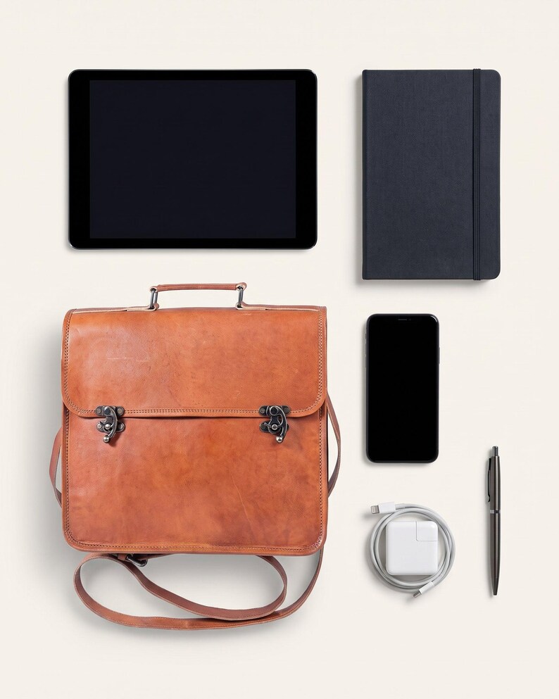 The Jodhpur Messenger, 11-inch size, shown with an 11-inch tablet, A5 notebook, phone, charger and pen to show what it holds (AI-generated)