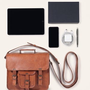 The Mewad Messenger, 11-inch size, shown with an 11-inch tablet, A5 notebook, phone, charger and pen to show what it holds (AI-generated)