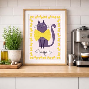 Pode incluir: Impressão emoldurada de um gato roxo com uma gravata borboleta amarela e a palavra "Farfalle" abaixo. O gato é cercado por formas de laço amarelo em um fundo rosa. A impressão é exibida em um ambiente de cozinha.