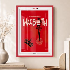 Peut inclure: Une affiche encadrée sur fond rouge vif avec le texte blanc William Shakespeare's MACBETH. Un graphique noir représentant une dague pointant vers le bas vers un motif en rayons de soleil et une couronne noire sont centrés sous le titre, avec 1623 en bas.